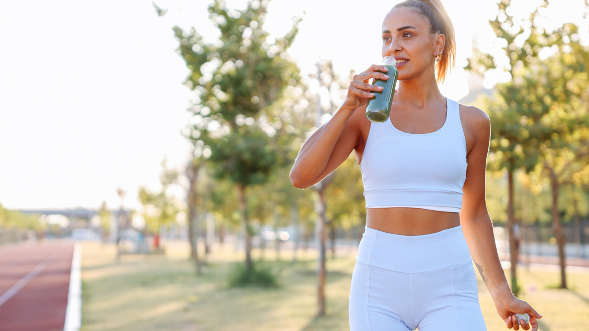 Woman drinking vegetable smoothie after fitness running workout