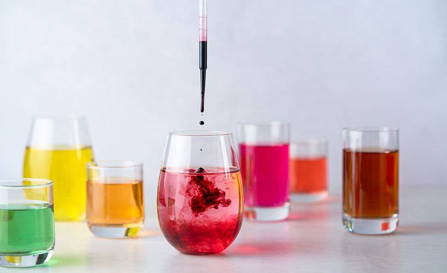 The image shows a series of colorful liquid samples in small jars.