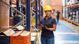 woman in a warehouse wearing a hard hat