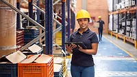 woman in a warehouse wearing a hard hat