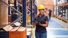 woman in a warehouse wearing a hard hat