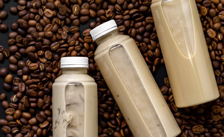 The image displays bottles of ready-to-drink iced coffee or latte beverages. 