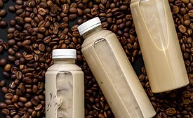 The image displays bottles of ready-to-drink iced coffee or latte beverages. 