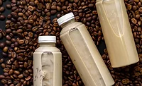 The image displays bottles of ready-to-drink iced coffee or latte beverages. The image displays bottles of ready-to-drink iced coffee or latte beverages.