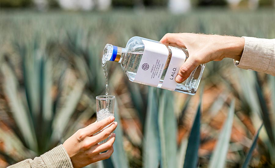 Pouring LALO tequila into a shot cup