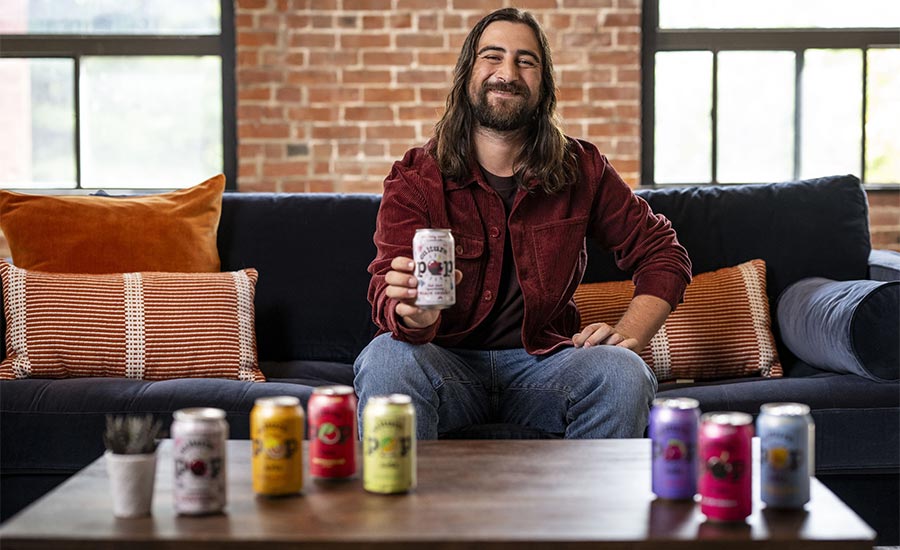 Singer-songwriter Noah Kahan holding a can of Culture Pop Soda.