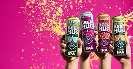 Hands holding cans of Goose Island Beer Co.'s Beer Hug IPA in Pineapple, Tropical, Juicy, and Mango flavors