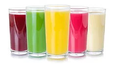 This image displays a collection of colorful fruit juices and smoothies in clear glasses against a white background. 