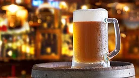 a cold mug of beer on a wooden barrel
