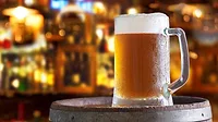 a cold mug of beer on a wooden barrel