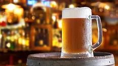 a cold mug of beer on a wooden barrel