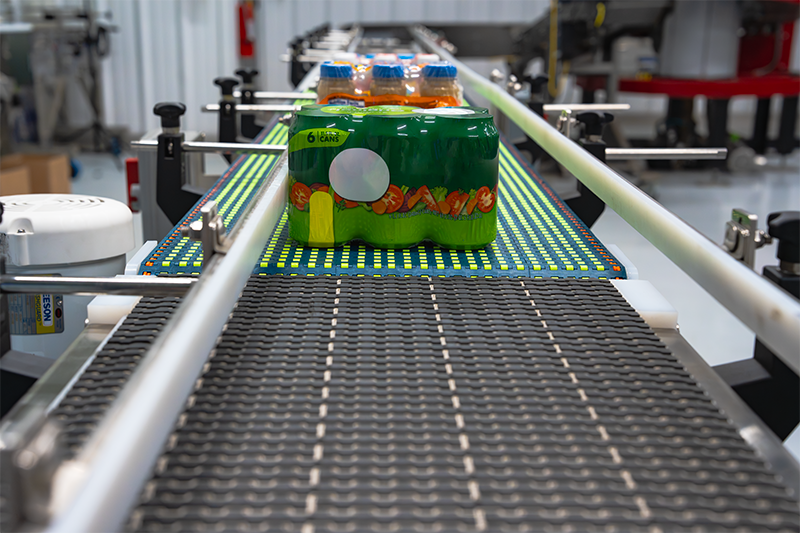a multi-pack of juice bottles moving along an automated modular belt conveyor system