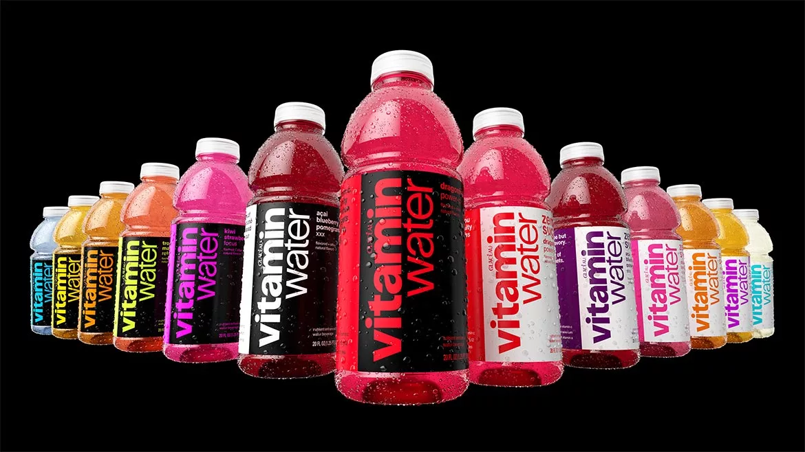The image features various flavors of Vitaminwater, a brand of enhanced bottled water owned by The Coca-Cola Company.