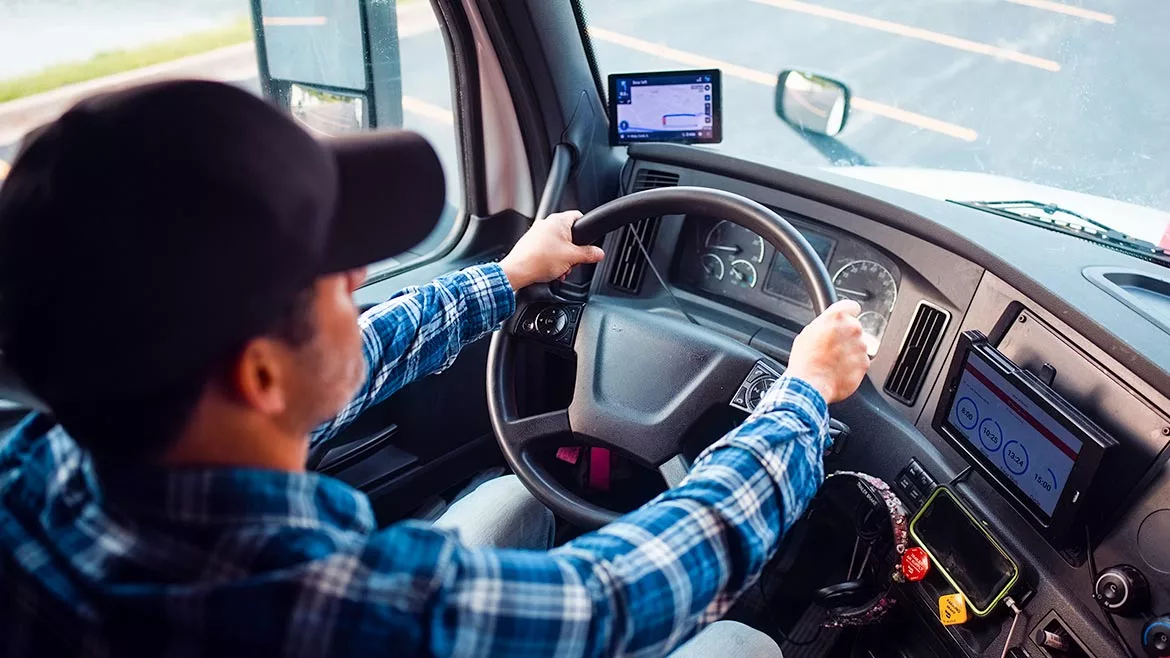 This image depicts a truck driver operating a commercial vehicle