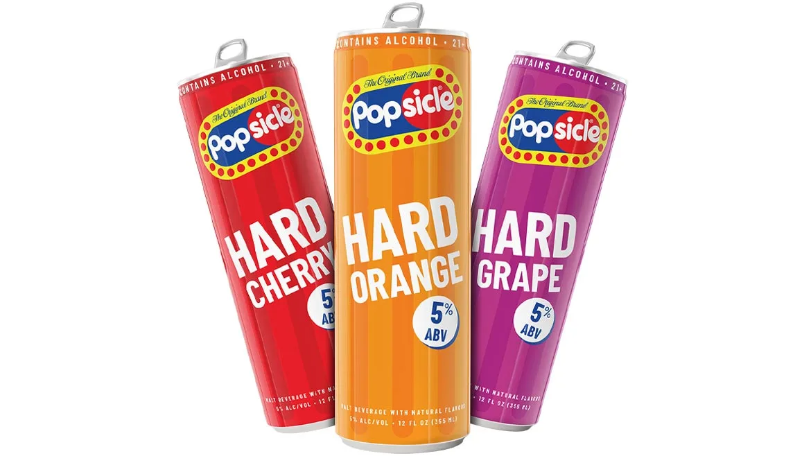 three 12-ounce cans of Popsicle Hard flavored malt beverages in Hard Cherry (red), Hard Orange (orange), and Hard Grape (purple)