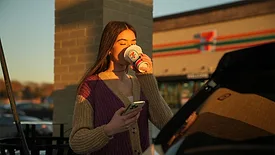 a person wearing a cozy purple knit sweater vest layered over textured beige sleeves.